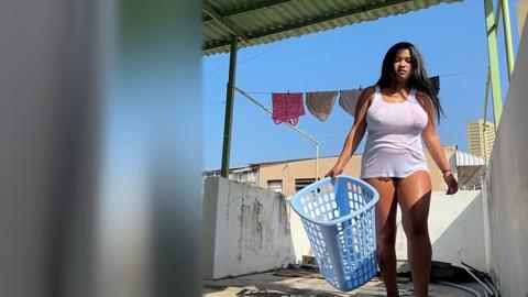 I sneakily watch my curvy neighbor as she hangs laundry